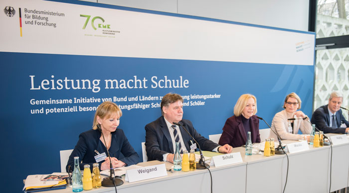 Bild von der Auftaktveranstaltung: Frau Weigand, Herr Schulz, Frau Wanka und Frau Hubig sitzen nebeneinander auf dem Podium, Frau Wanka spricht ins Mikrofon